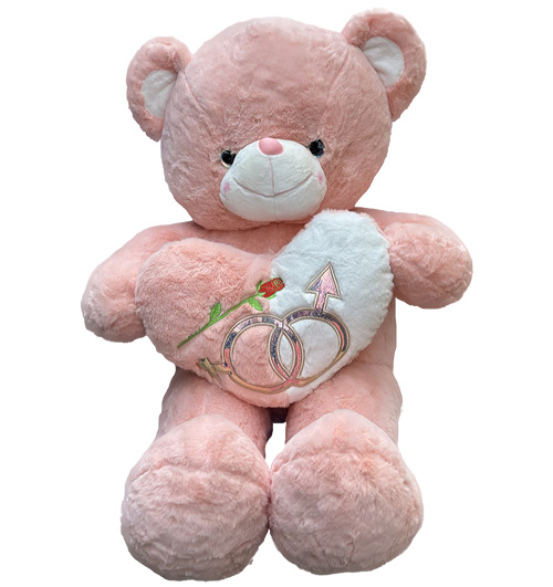 Pink teddy bear hugs heart